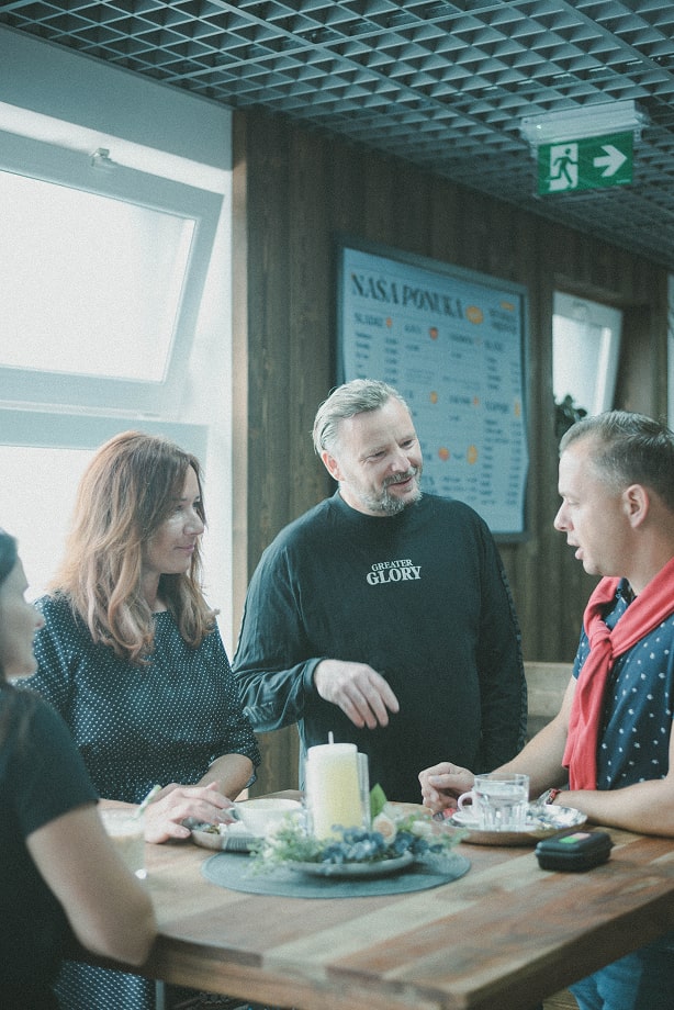 Priatelia v neformálnom rozhovore pri stole.