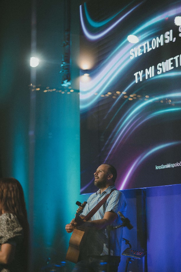 Hudobník s gitarou, živá hudba v sále.