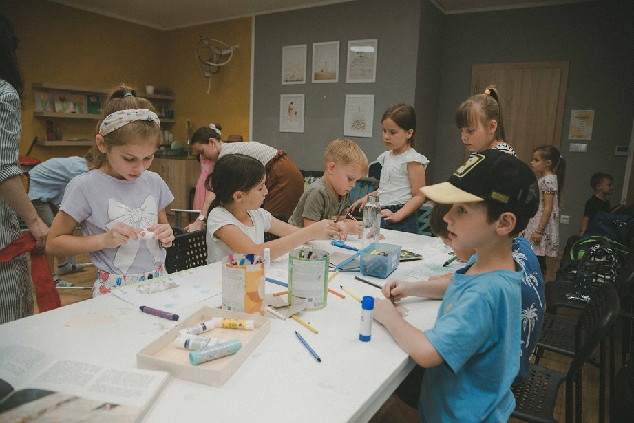 Deti tvoria a maľujú v klube.